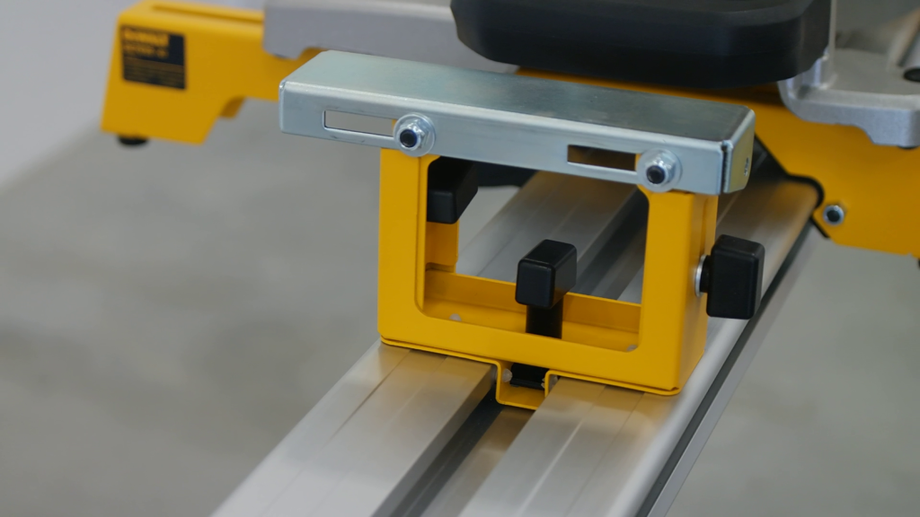 DeWALT DE7024 work support bracket mounted on a portable miter saw with the surface prepared for drilling mounting holes.