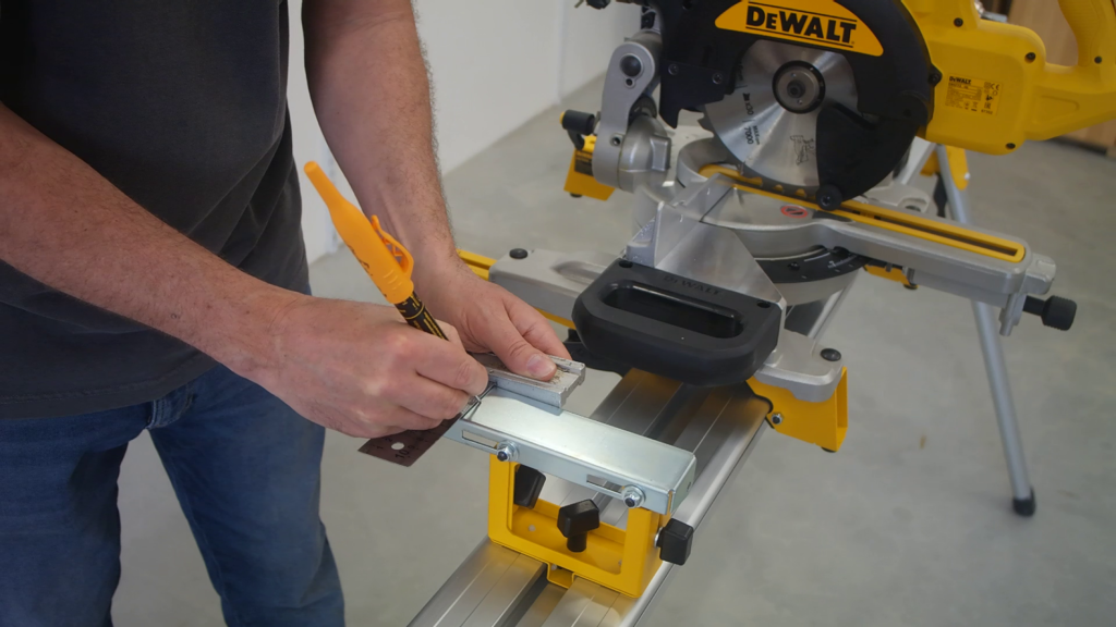 DeWALT DE7024 work support bracket being marked with a marker for drilling mounting holes.