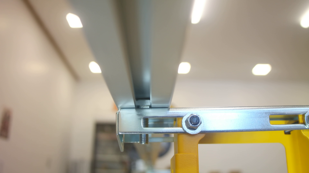 A T-head bolt inserted in the bottom of a Pedante Digital Miter Saw Fence with the head turned perpendicular to the rail.