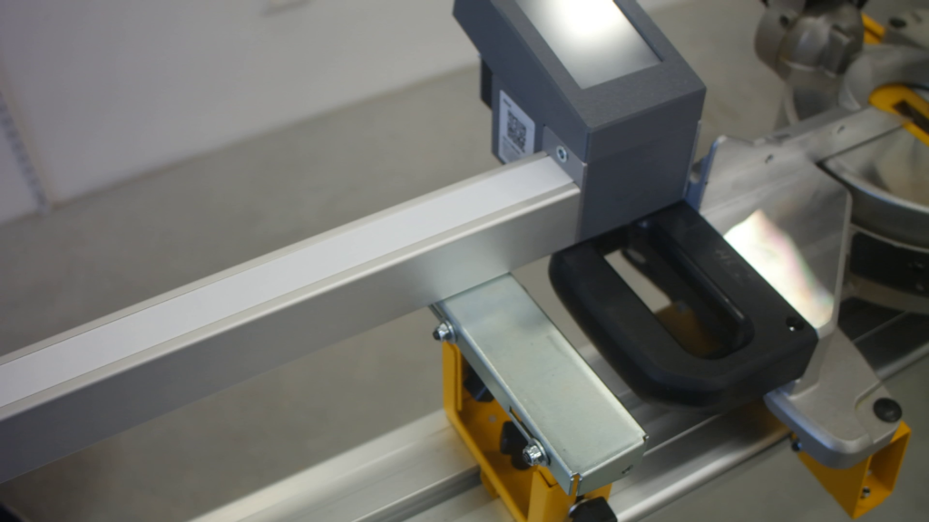 Pedante Automated Length Stop mounted on a portable miter saw stand, not aligned with the saw fence.