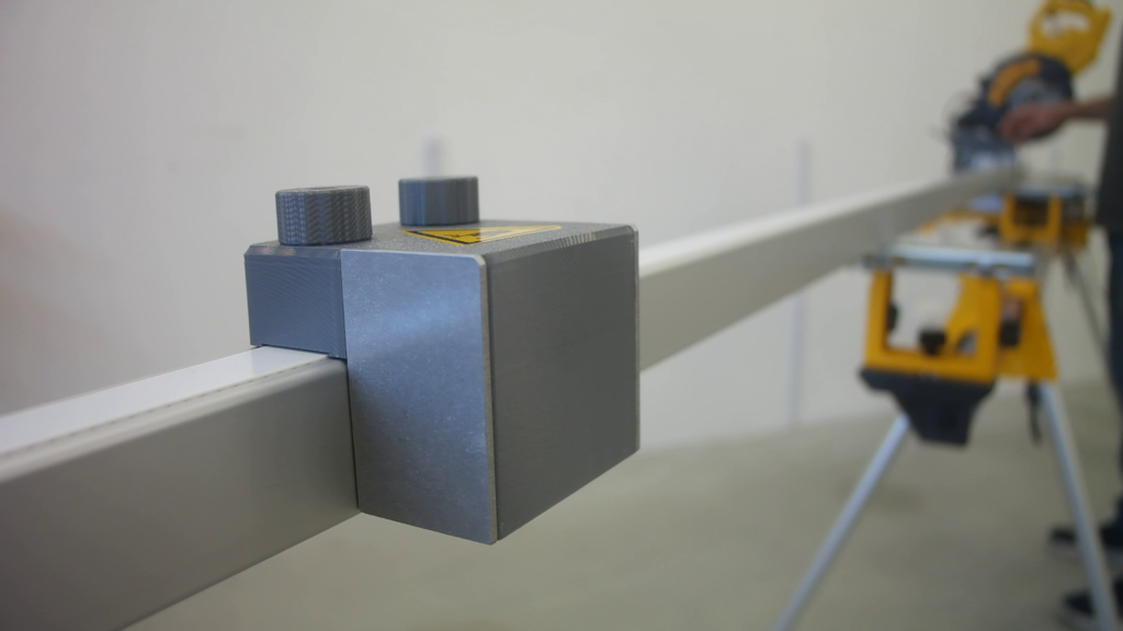 Closeup of the Pedante Digital Miter Saw Fence stop block mounted on a DeWALT portable miter saw stand.