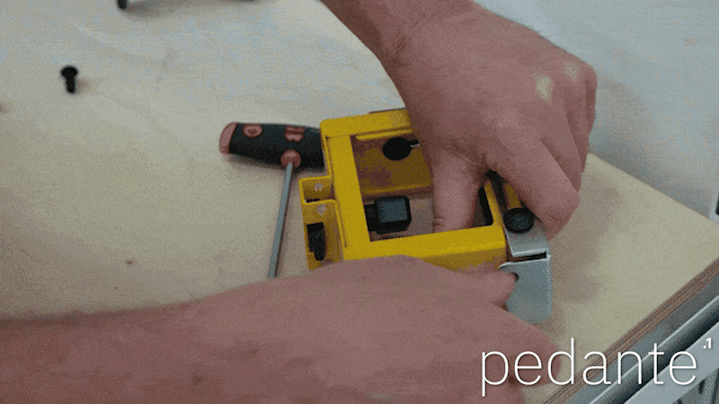 Moving the work support’s height adjustment knob inward to clear the Pedante rail mounting bolts