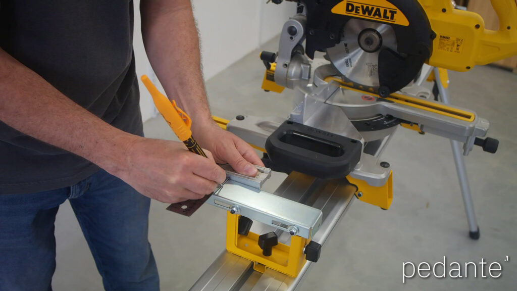 Marking the Pedante rail mounting hole on the DeWALT work support with a square and marker