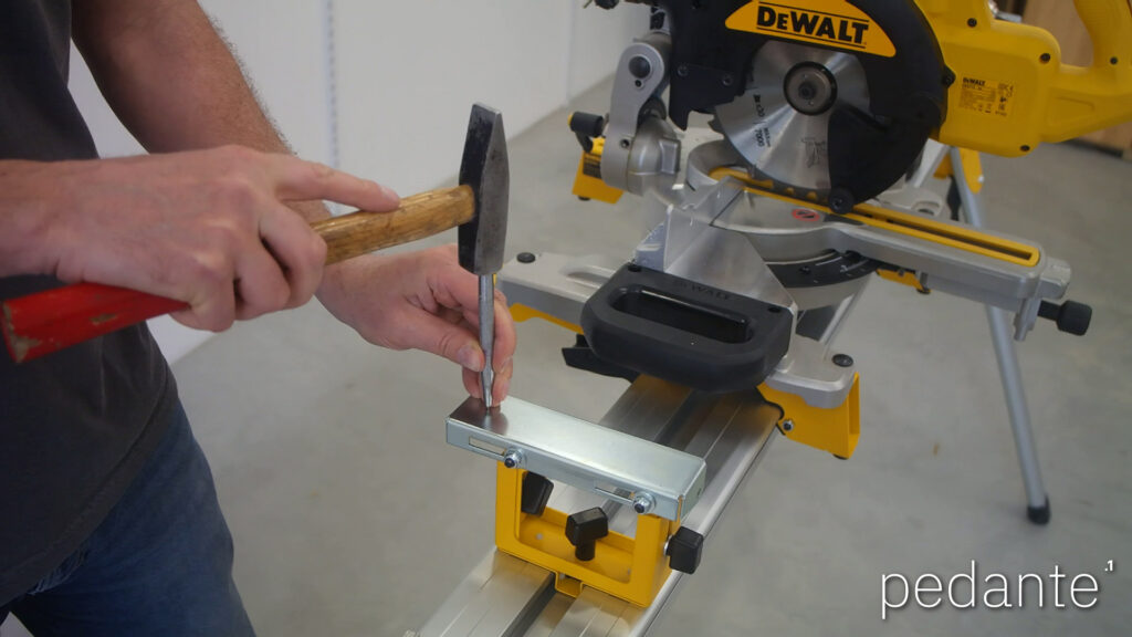 Center punching the marked mounting hole for the Pedante automatic miter saw fence