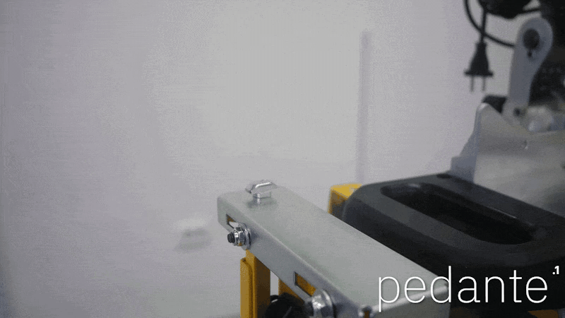Lowering the Pedante rail onto the T-head mounting bolts beside the DeWALT miter saw